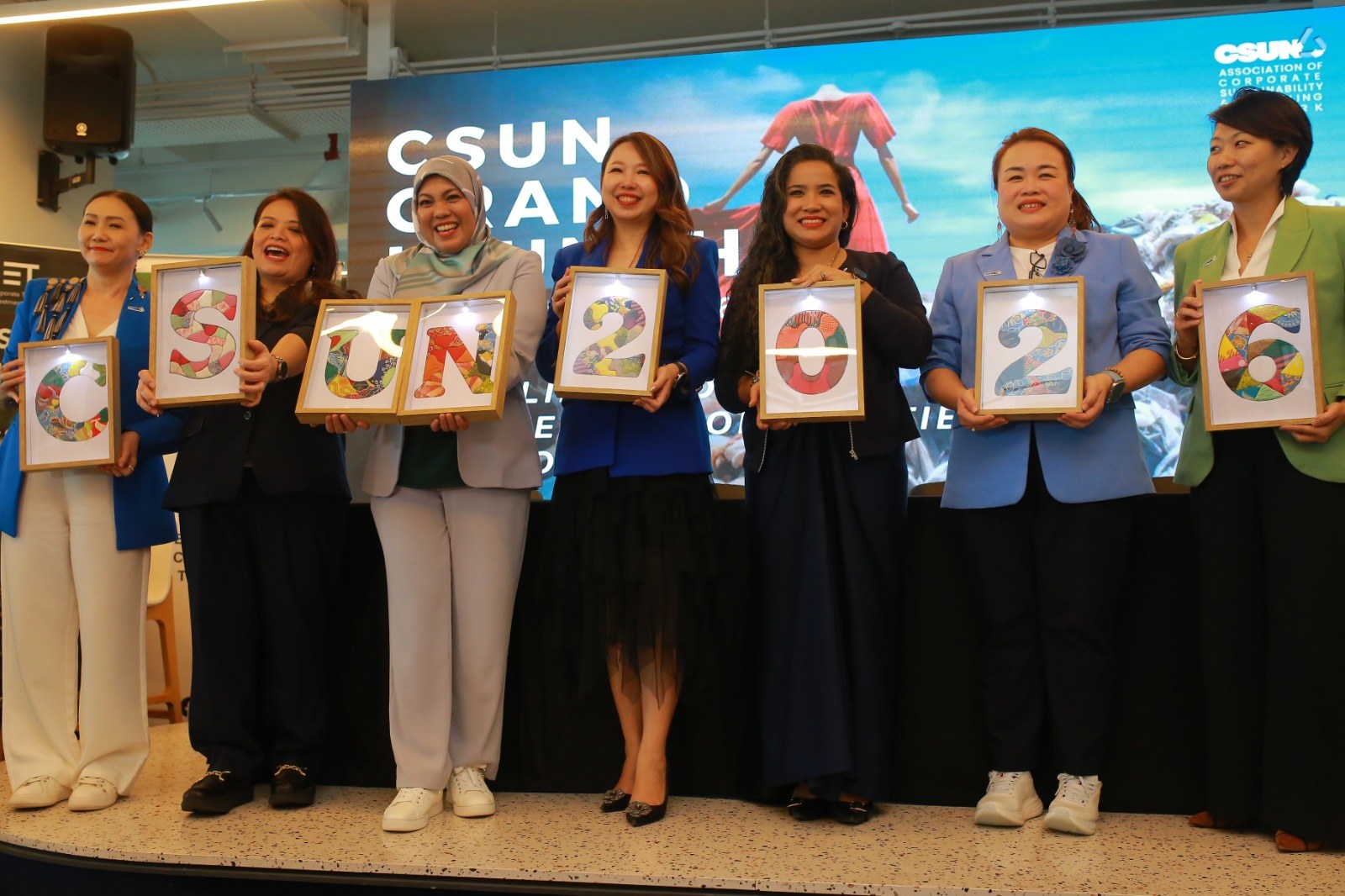CSUN 领导团队在启动典礼台上手持拼出 CSUN 2026 的拼布字母相框